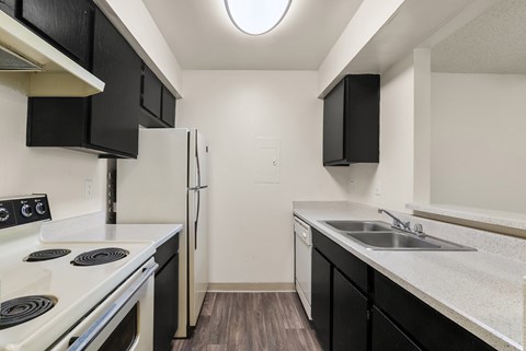 A kitchen with black cabinets and a white stove top oven.