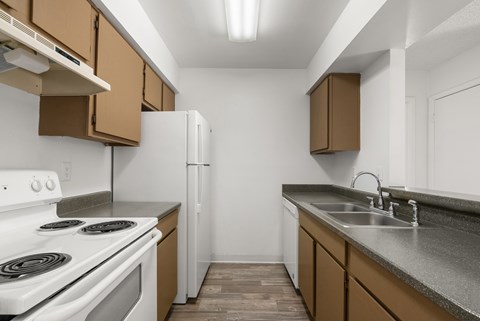 A kitchen with white appliances and brown cabinets.