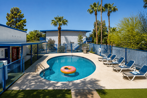 A pool with a blue fence and a red inflatable ring.