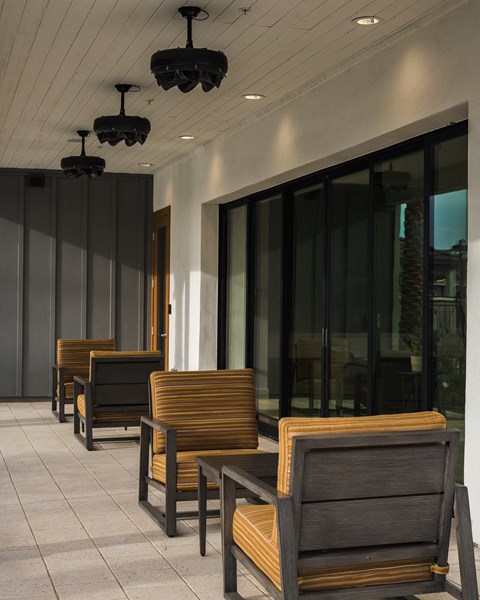 A row of wooden chairs are lined up on a patio.