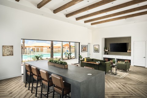 A modern kitchen with a bar area and a view of a pool and palm trees.