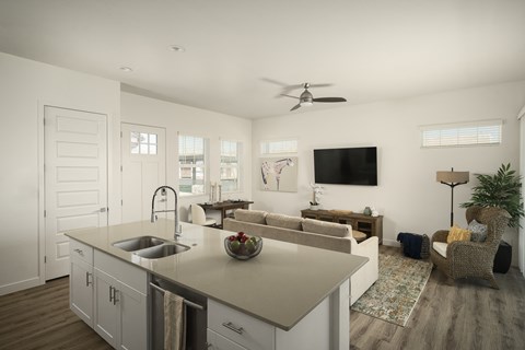 A modern kitchen with a large island and a flat screen TV mounted on the wall.