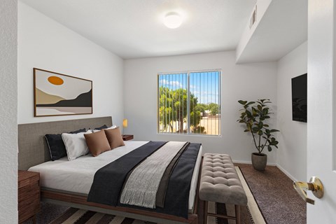 A bedroom with a large bed and a painting on the wall.
