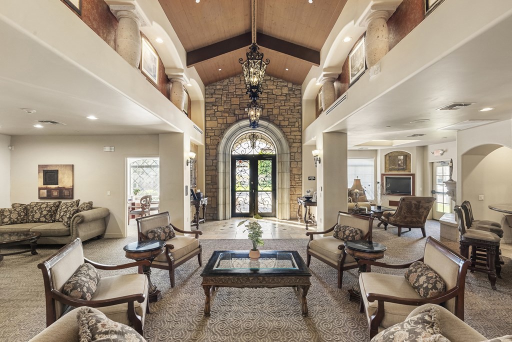 A large, well-furnished living room with a chandelier and a fireplace.