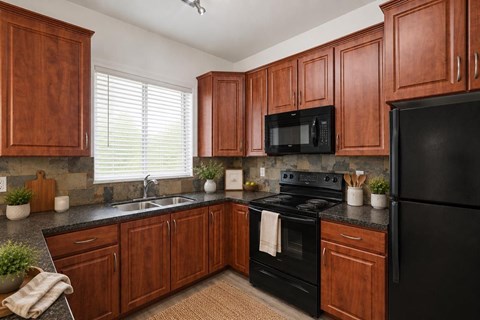A kitchen with wooden cabinets and black appliances.