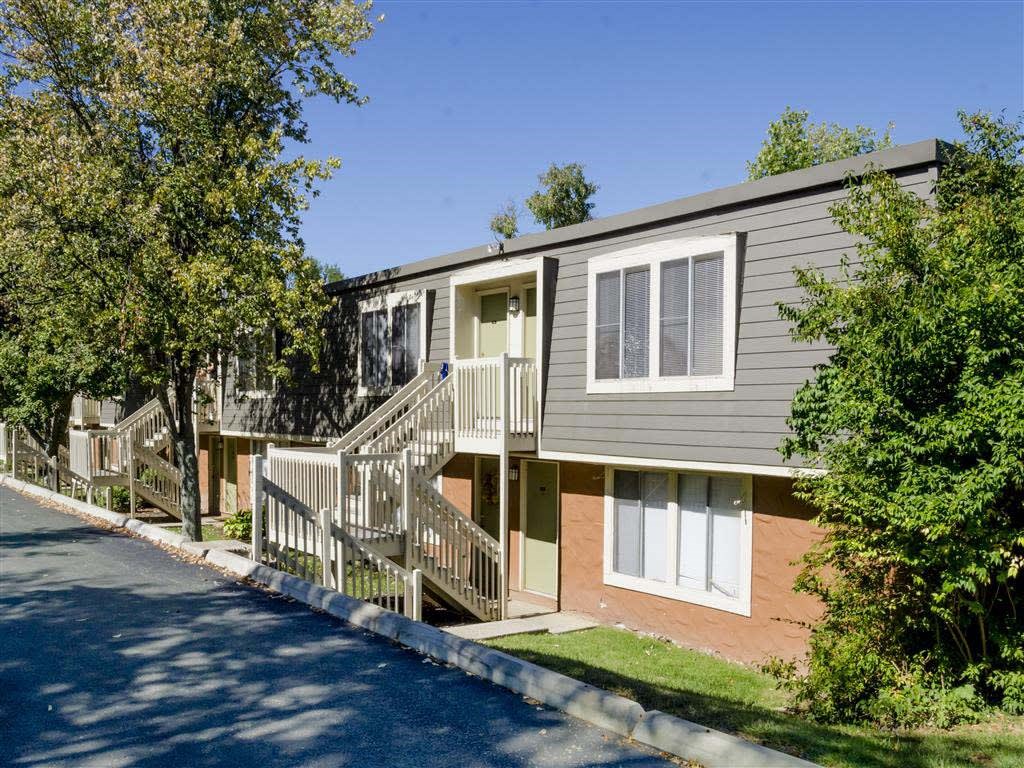 A row of houses with a tree in front of the first house.