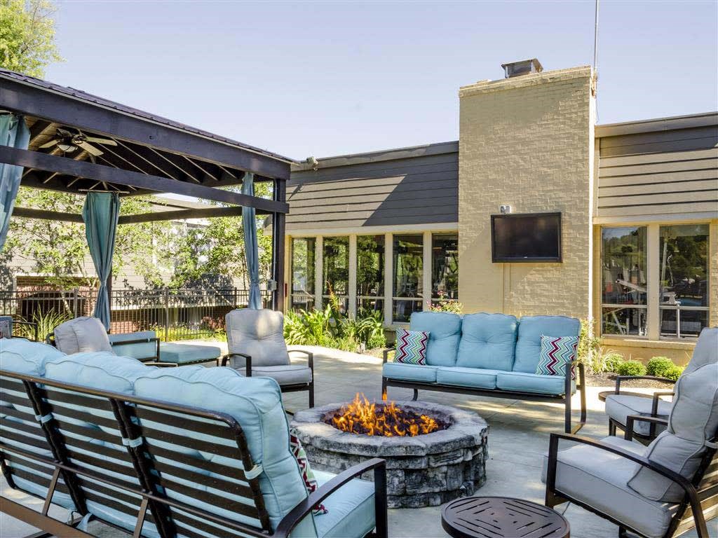 A patio with a fire pit and seating area.