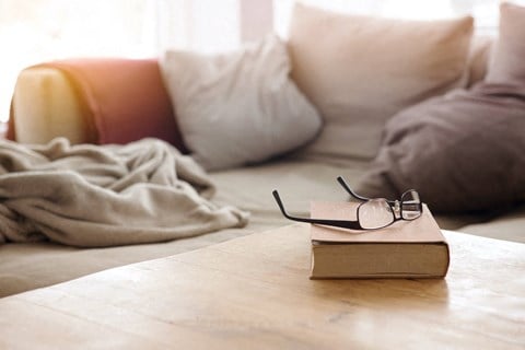 a book with glasses sitting on a table in a living room