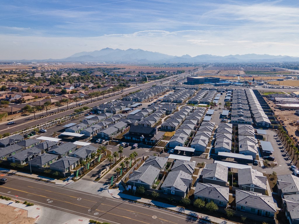 an aerial view of a suburb of houses and an airport with mountains in the background