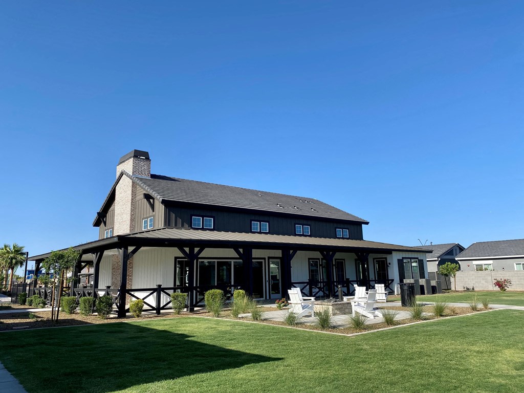 a large house with a lawn and a blue sky