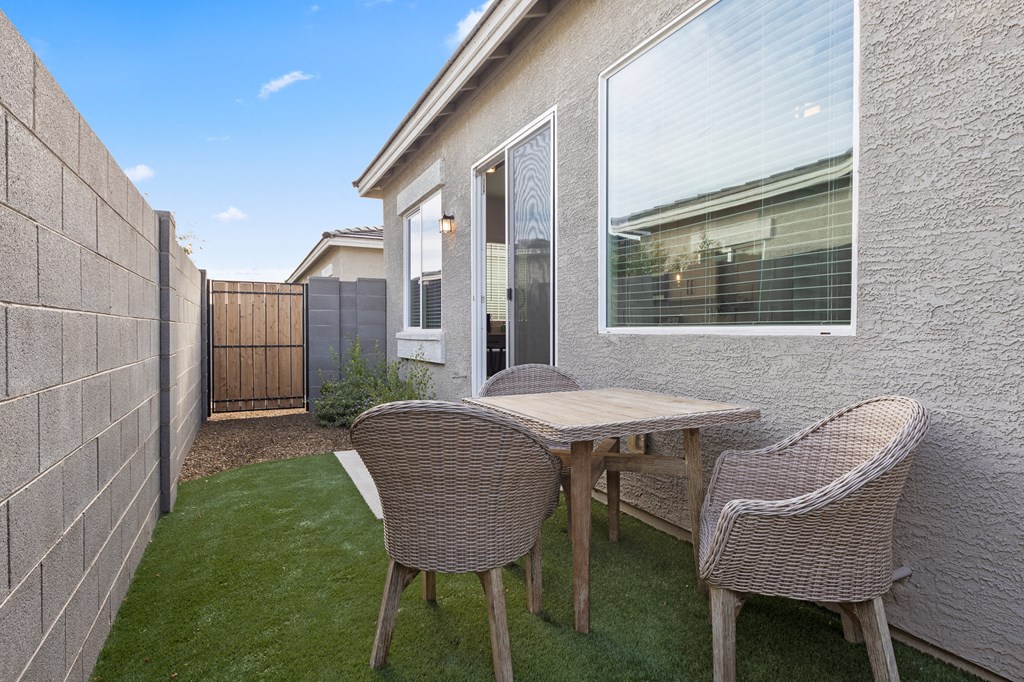 a patio with a table and chairs in front of a house