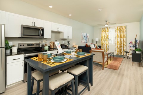 A kitchen with a table set for two with plates and glasses on it.