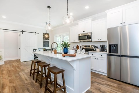 A kitchen with white cabinets and a wooden island.