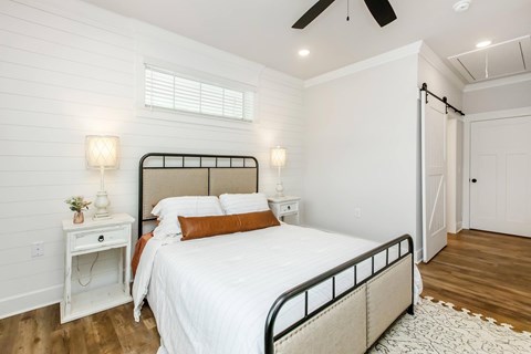A bedroom with a large bed and a ceiling fan.