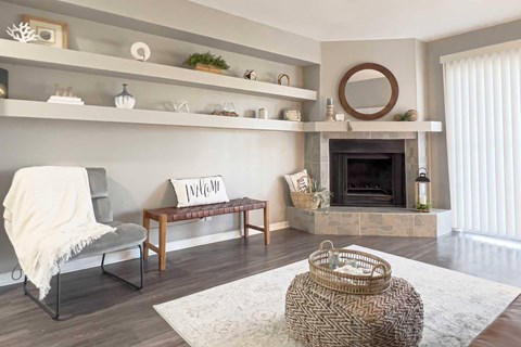A cozy living room with a fireplace and a chair with a white blanket.