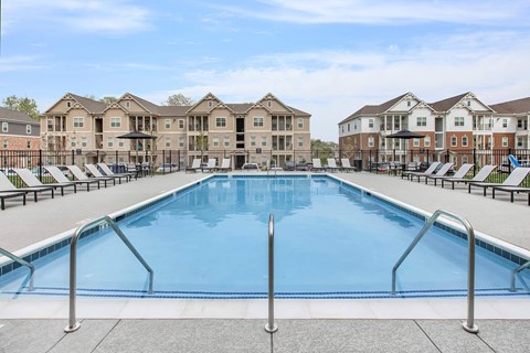 A large swimming pool in front of apartment buildings.