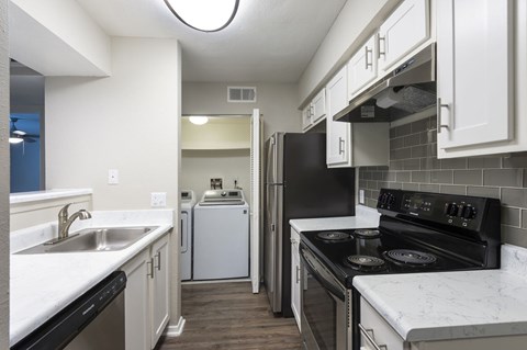 A kitchen with black appliances and white cabinets.