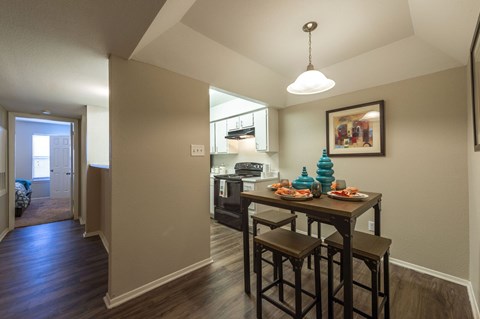 A dining room with a table and chairs.