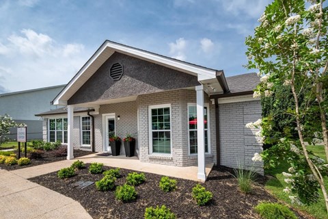 A small house with a grey roof and white walls.