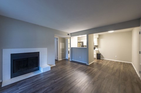 A living room with a fireplace and a wooden floor.
