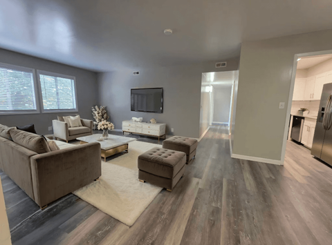 A modern living room with a grey sofa set and a television.