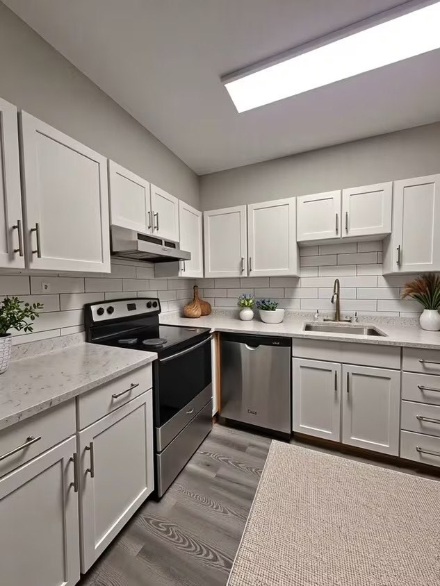 A kitchen with white cabinets and a black stove top oven.