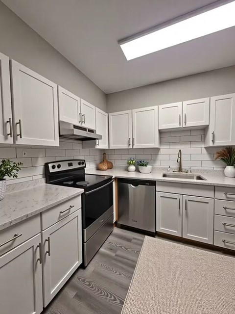A kitchen with white cabinets and a black stove top oven.