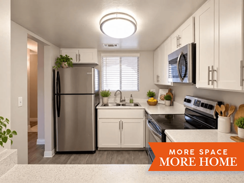 A kitchen with a refrigerator, sink, and oven.