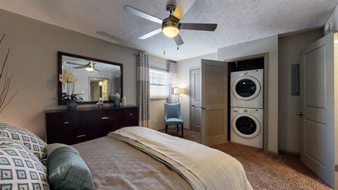 A bedroom with a bed, a dresser, a mirror, and a washing machine.