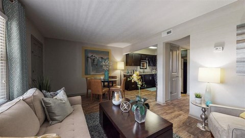 A living room with a couch, coffee table, and a painting on the wall.