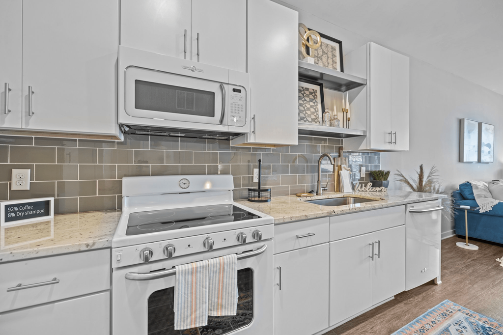 A kitchen with white appliances and cabinets.