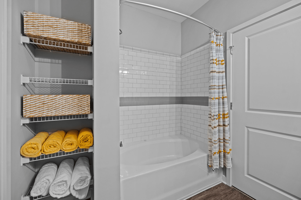 A white bathroom with a towel rack and a bathtub.