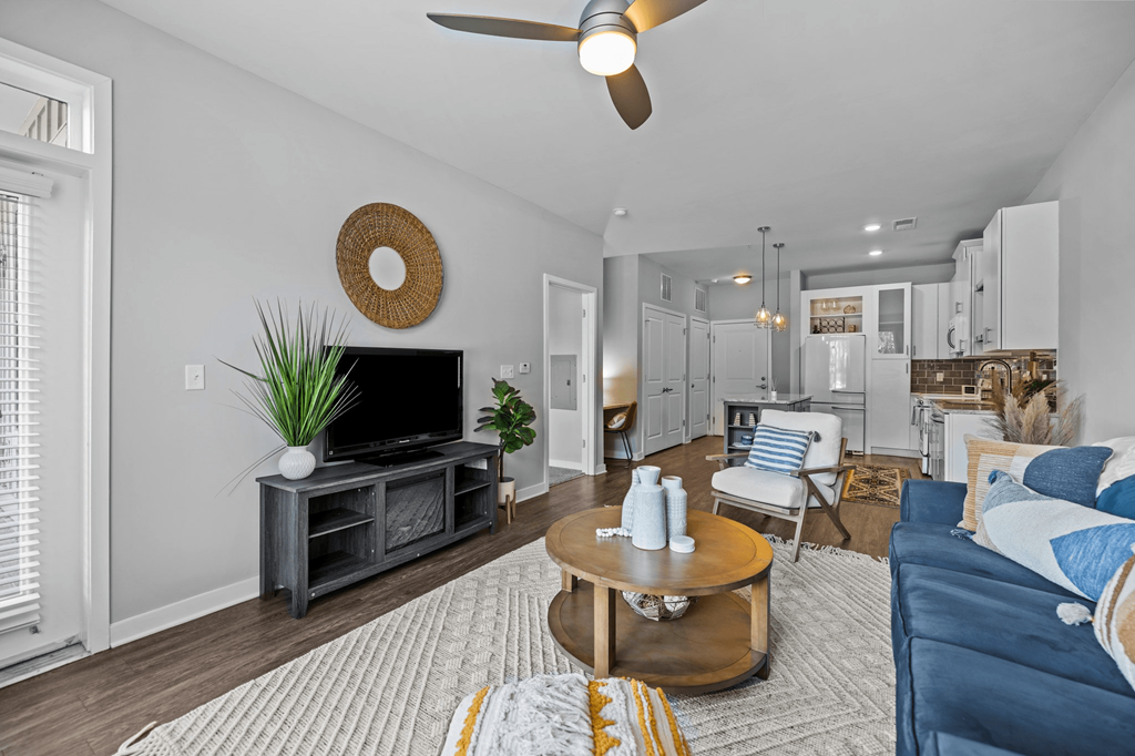 A living room with a blue couch and a wooden coffee table.
