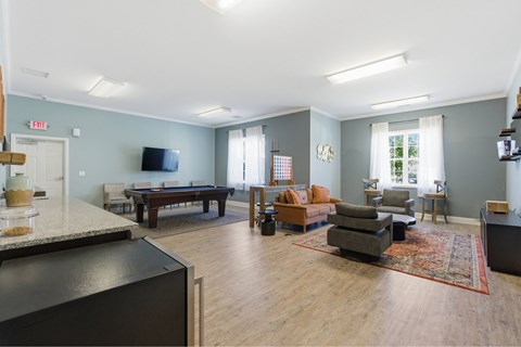 A living room with a pool table and a television.