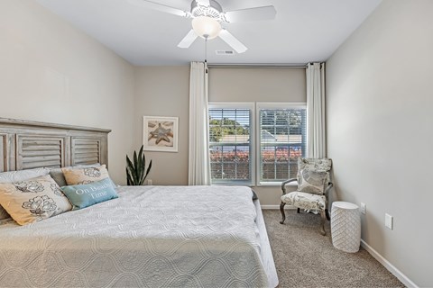 A bedroom with a large bed and a ceiling fan.
