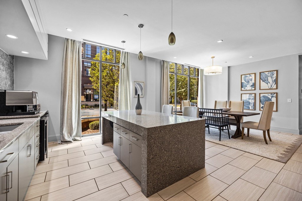 A modern kitchen with a large island and a dining table.