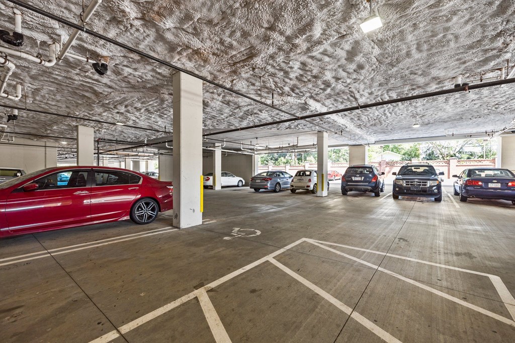 A parking garage with a red car in the foreground.