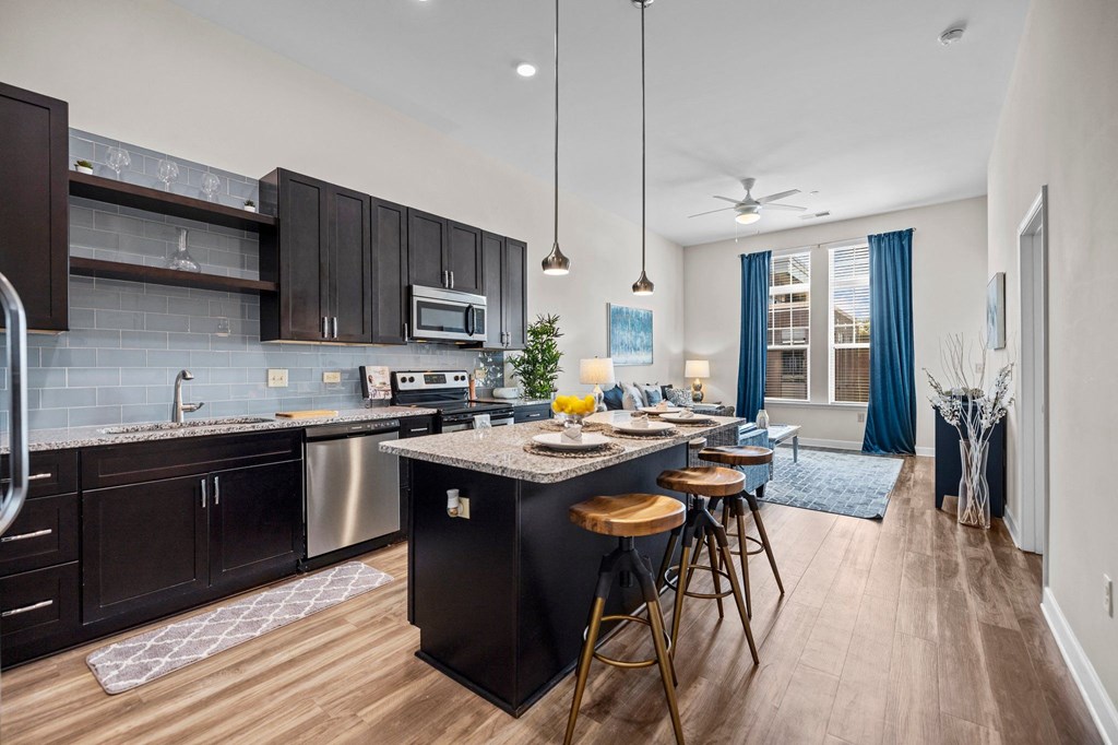 A modern kitchen with dark wood cabinets and a large island.