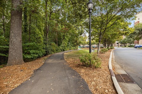 A tree-lined path runs alongside a sidewalk.