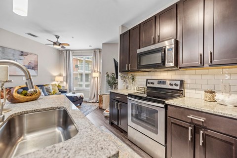A kitchen with brown cabinets and a stainless steel sink.