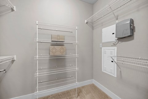 A white pantry with a white fridge and a white cabinet.