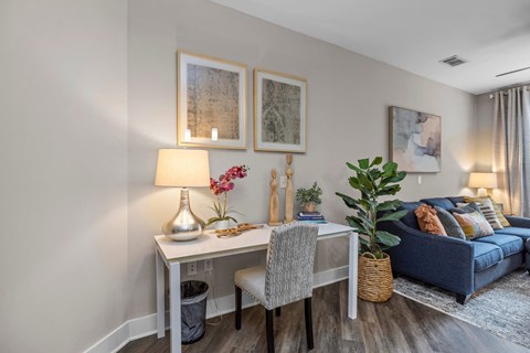A well-lit room with a desk, chair, and a couch.
