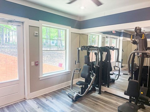 A gym with a variety of equipment including treadmills and weights.