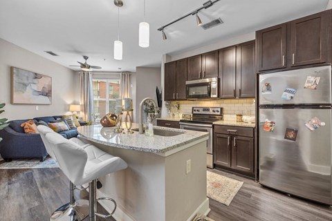 A kitchen with a white countertop and a refrigerator with magnets on it.