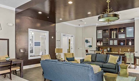 A living room with a blue couch and a chandelier.
