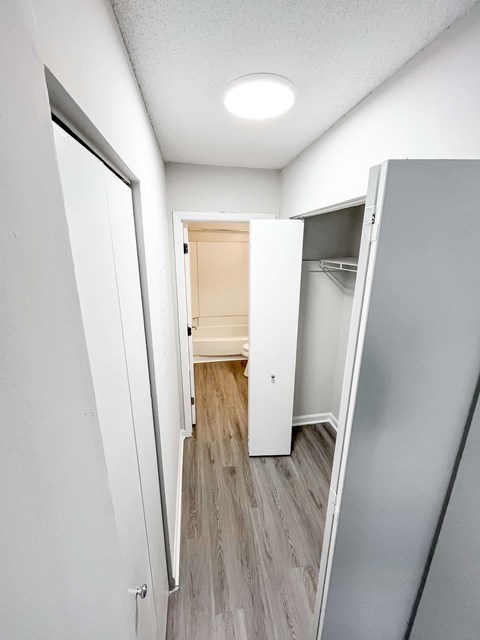 A hallway with a white door and a grey wall.