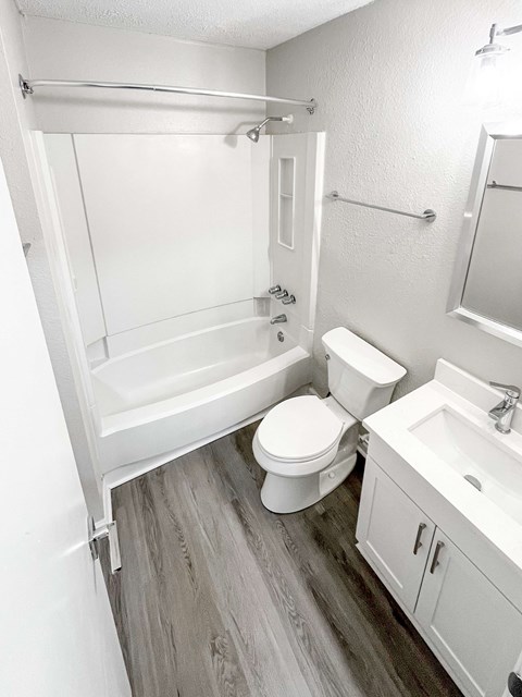 A white bathroom with a toilet, sink, and bathtub.