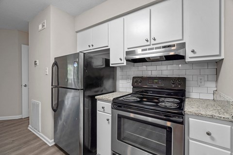 A kitchen with a black refrigerator and stove.