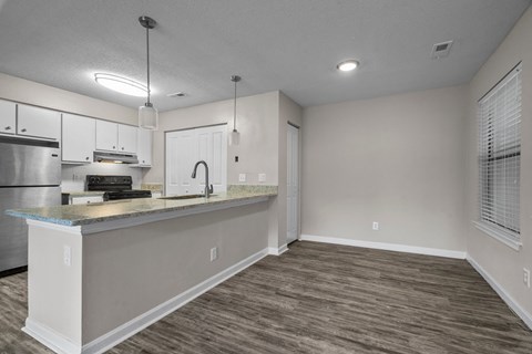A kitchen with a stainless steel refrigerator and a white countertop.