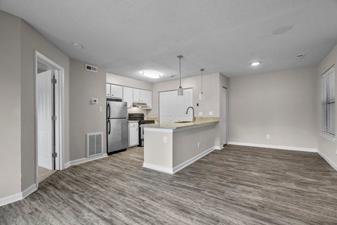 A kitchen with a refrigerator, stove, and sink.